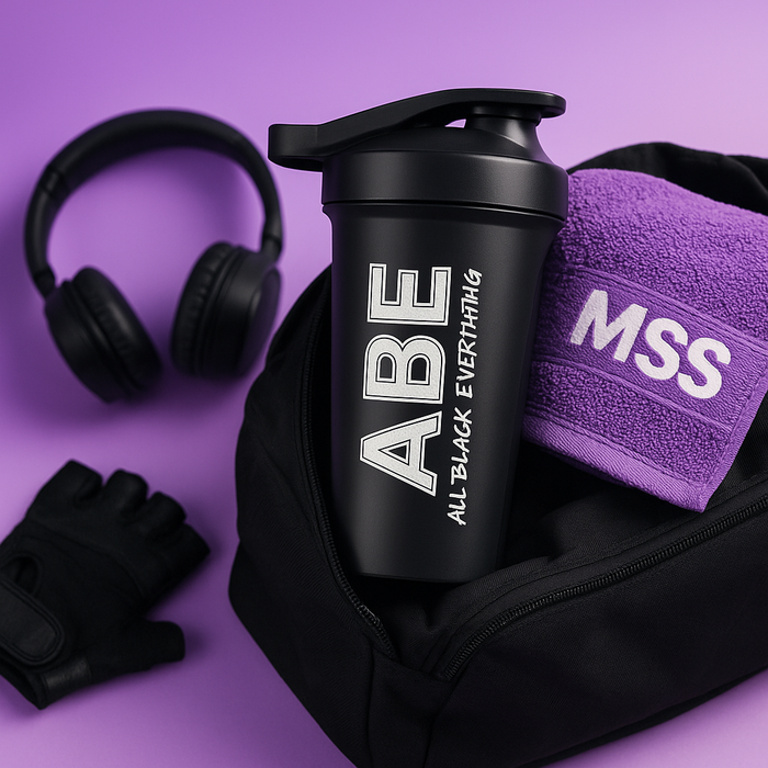 The ABE shaker is peeking out of a black gym bag with a MySupplementShop (MSS) purple towel and headphones in the background.