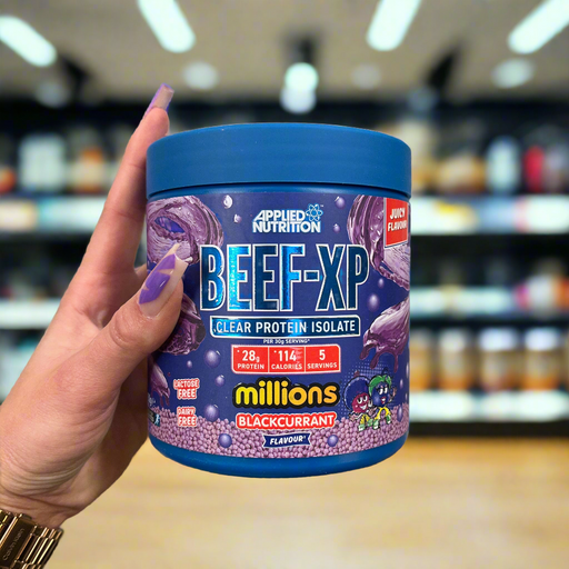 Close-up of (Applied Nutrition Beef-XP 150g) held up inside My Supplement Shop, clearly showing the front label in a Sports Nutrition setting.