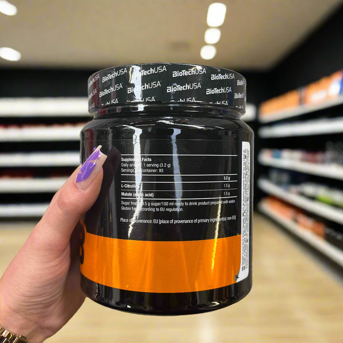 Close-up of (BioTechUSA Citrulline Malate, Green Apple - 300 grams) held up inside My Supplement Shop, clearly showing Nutritional Values on the packaging in a Sports Nutrition setting.