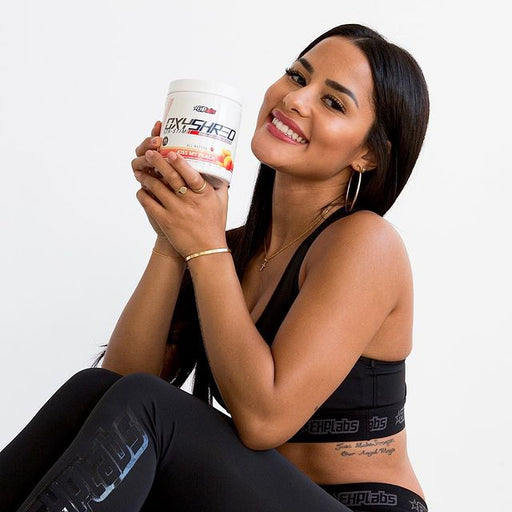 Smiling woman holding EHP Labs OxyShred Non-Stim for fat loss and energy boost