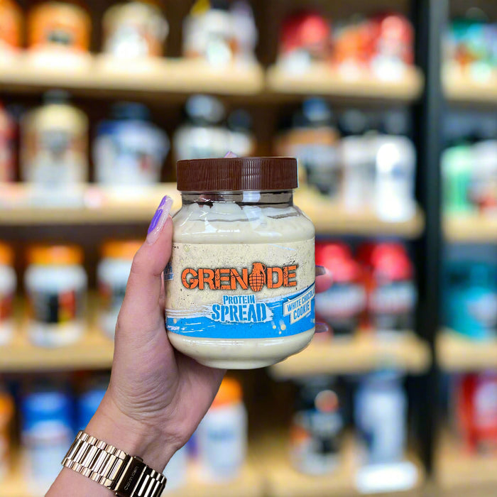 Close-up of (Grenade Protein Spread 360g) held up inside My Supplement Shop, clearly showing the front label in a Sports Nutrition setting.