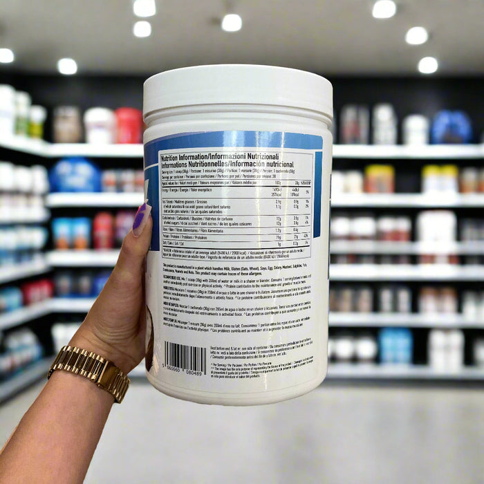 Close-up of (PER4M Whey Protein Powder 900g) held up inside My Supplement Shop, clearly showing Nutritional Values on the packaging in a Sports Nutrition setting.