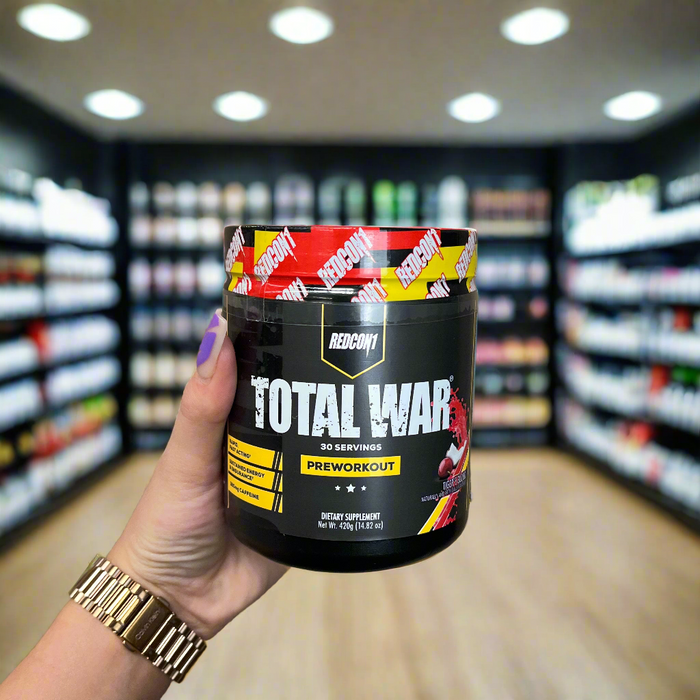 Close-up of (Redcon1 Total War Preworkout 30 Servings) held up inside My Supplement Shop, clearly showing the front label in a Sports Nutrition setting.