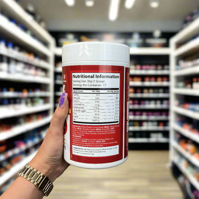 Close-up of (STRT Nutrition Whey Protein 500g ) held up inside My Supplement Shop, clearly showing Nutritional Values on the packaging in a Sports Nutrition setting.